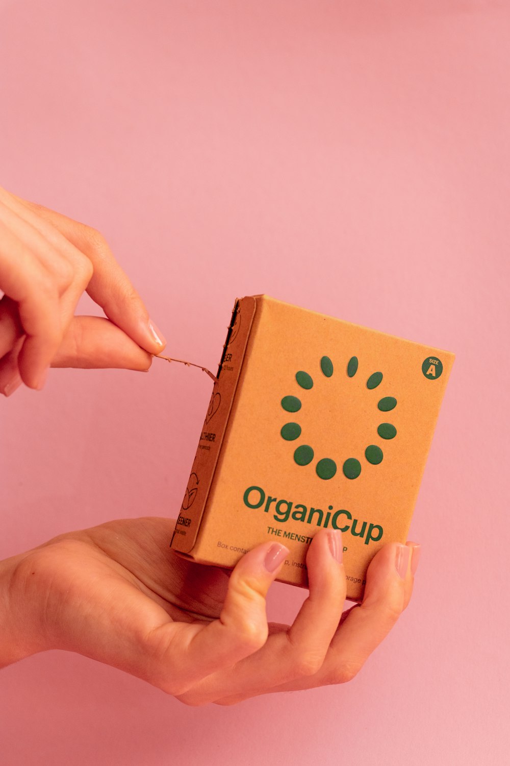 person holding brown and green cardboard box