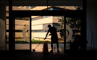 silhouette of man standing near glass window during daytime