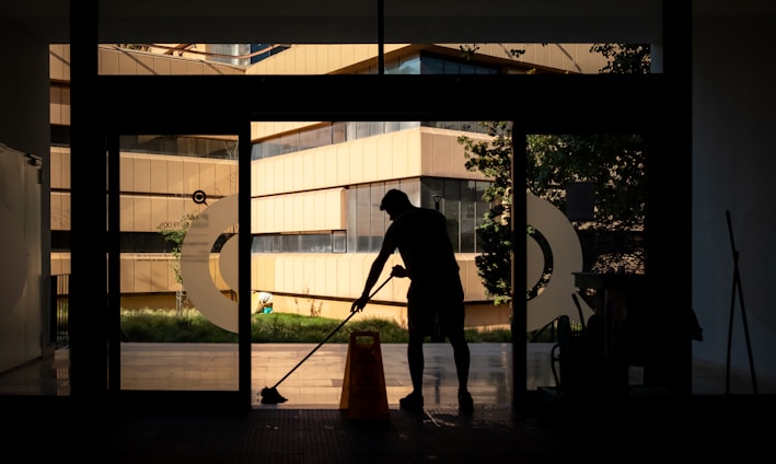 silhouette of man standing near glass window during daytime