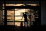 silhouette of man standing near glass window during daytime