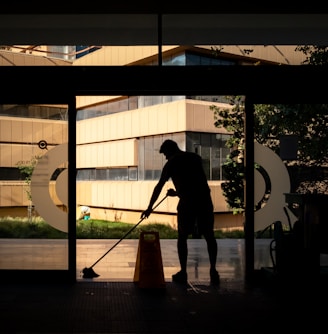 silhouette of man standing near glass window during daytime