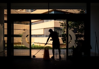 silhouette of man standing near glass window during daytime
