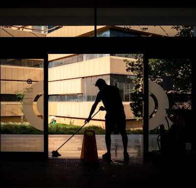 silhouette of man standing near glass window during daytime