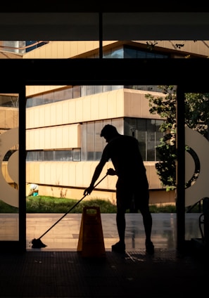 silhouette of man standing near glass window during daytime