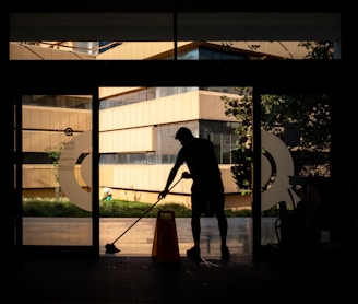 silhouette of man standing near glass window during daytime