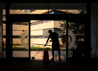 silhouette of man standing near glass window during daytime