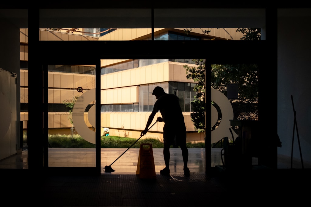 Commercial Cleaning Man cleans floor at an entrance door.