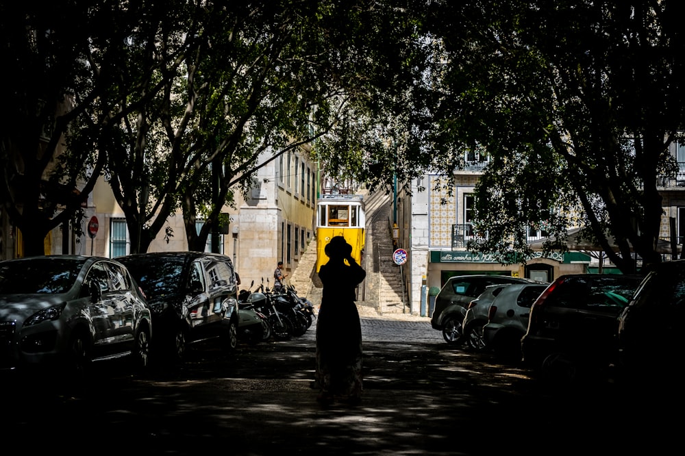 person in black jacket walking on sidewalk during daytime