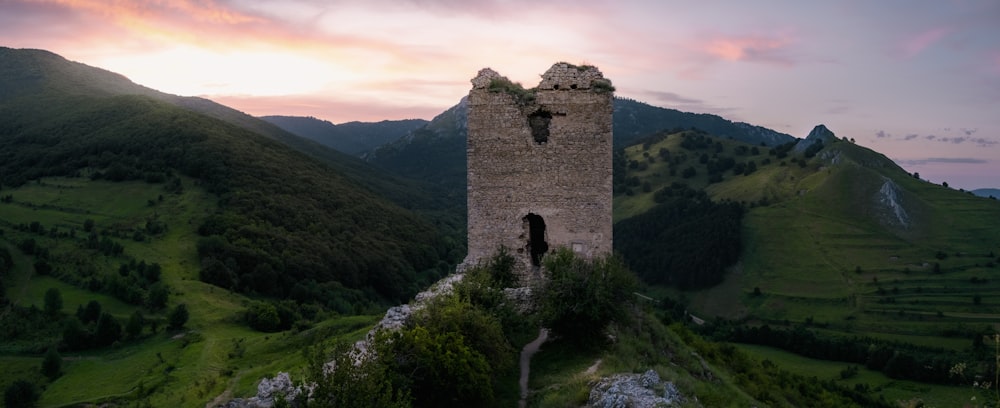 Bâtiment en béton brun sur un champ d’herbe verte pendant la journée