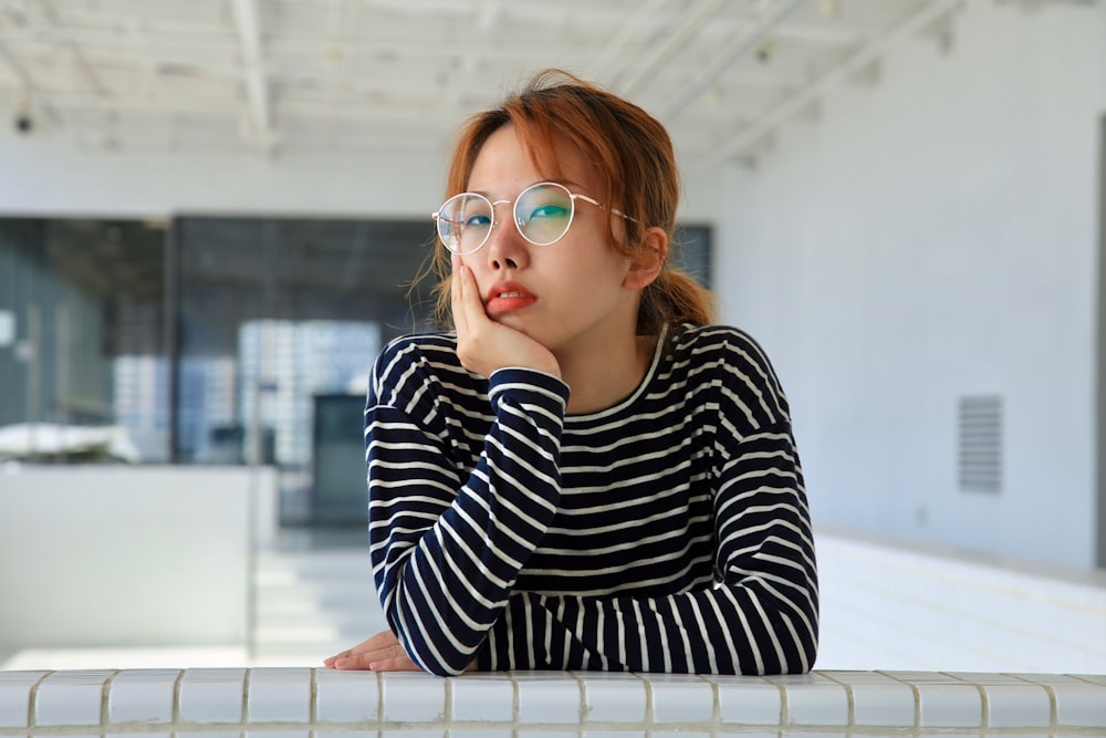 woman in black and white striped long sleeve shirt wearing blue framed eyeglasses