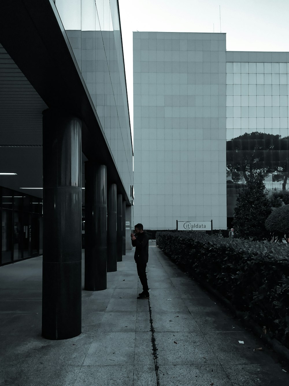 woman in black jacket and black pants standing on sidewalk during daytime