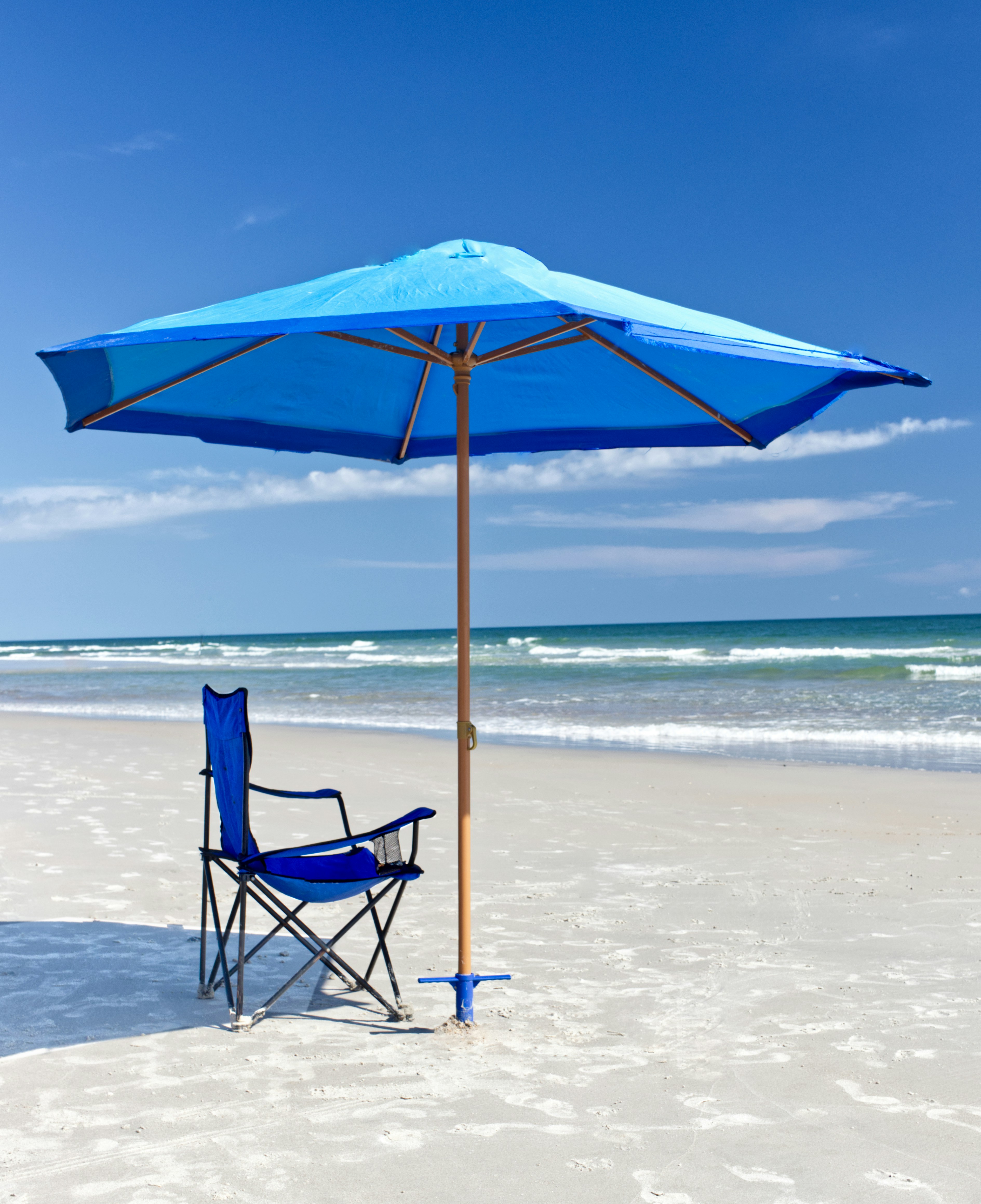 Blue umbrella on sunny beach.