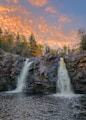 waterfalls on rocky mountain during sunset