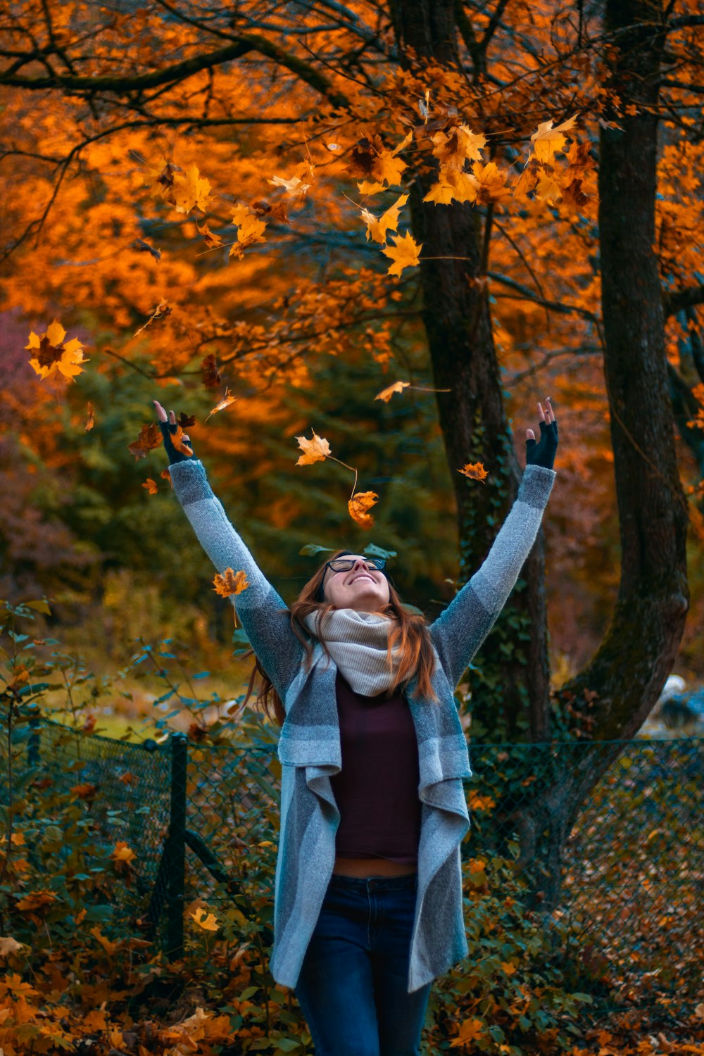 woman in brown coat standing near brown leaves tree during daytime