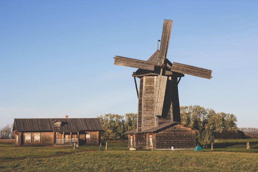 a windmill in the middle of a grassy field