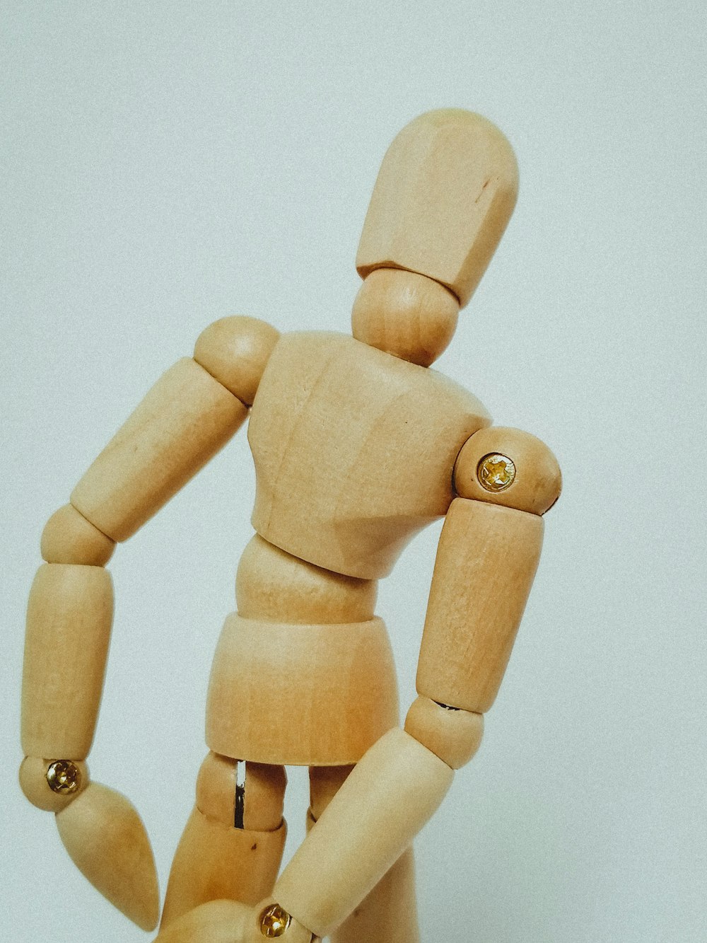 brown wooden human figure on white surface
