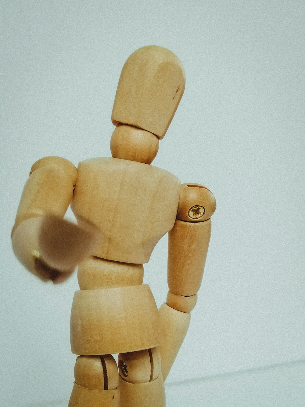 brown wooden human figure on white surface