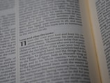 A close-up view of an open book showing a passage of text that discusses religious themes. The focus is on a specific section that begins with the phrase 'Love and obey the LORD'.