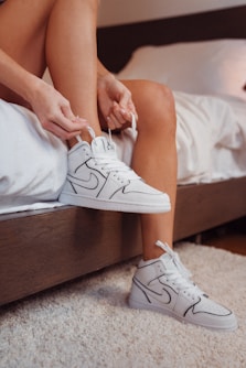 person wearing white nike sneakers