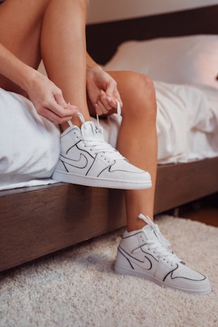 person wearing white nike sneakers