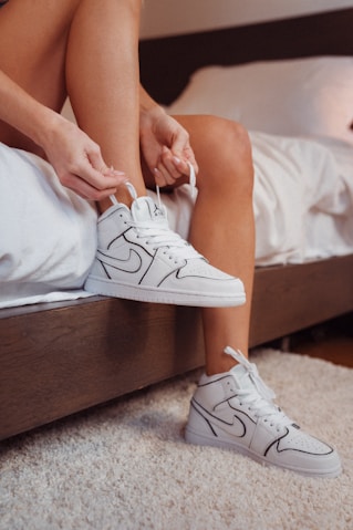 person wearing white nike sneakers