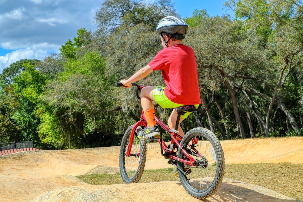 man in red shirt riding on bicycle