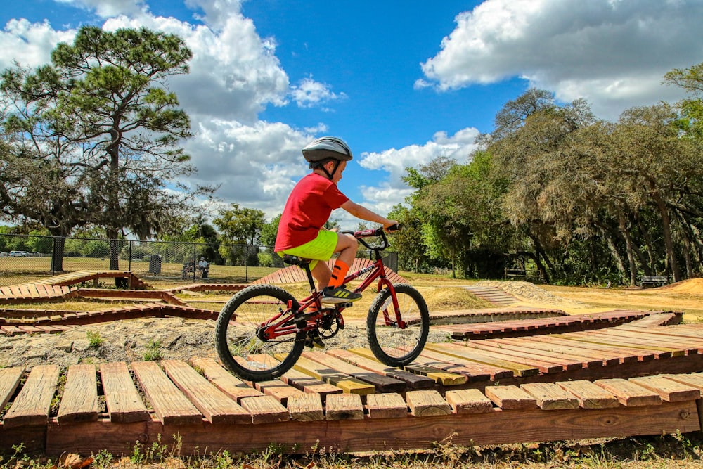 man in green shirt riding on bicycle during daytime