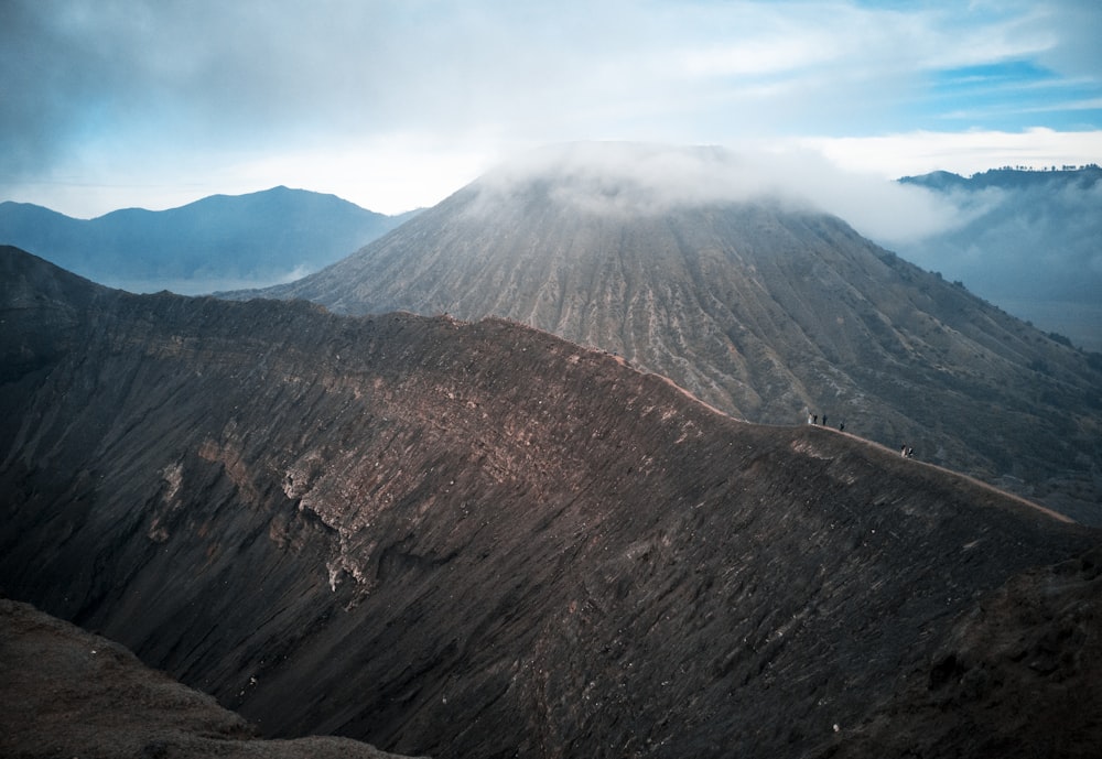 brown and green mountain under white clouds during daytime