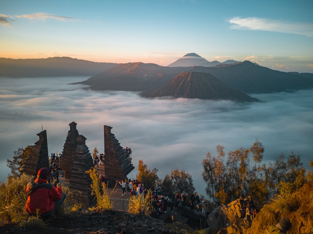 people sitting on rock formation near body of water during daytime