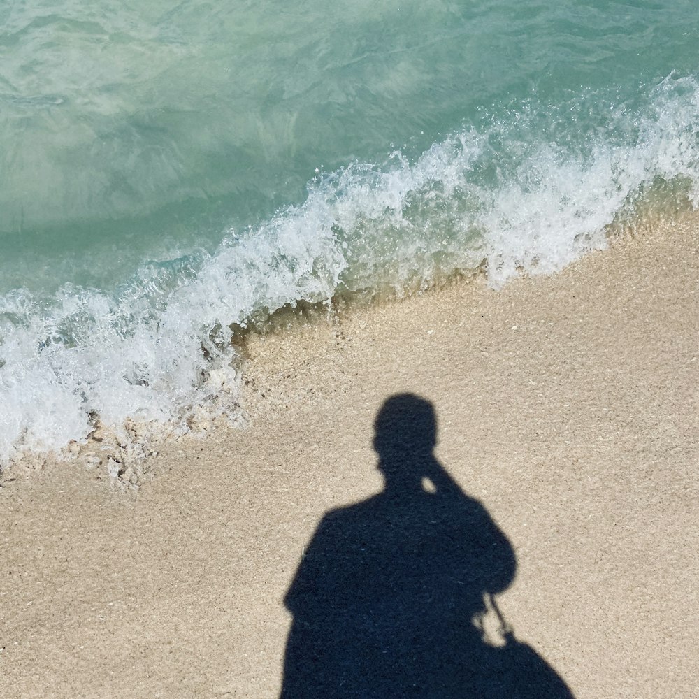 woman in black dress standing on beach during daytime