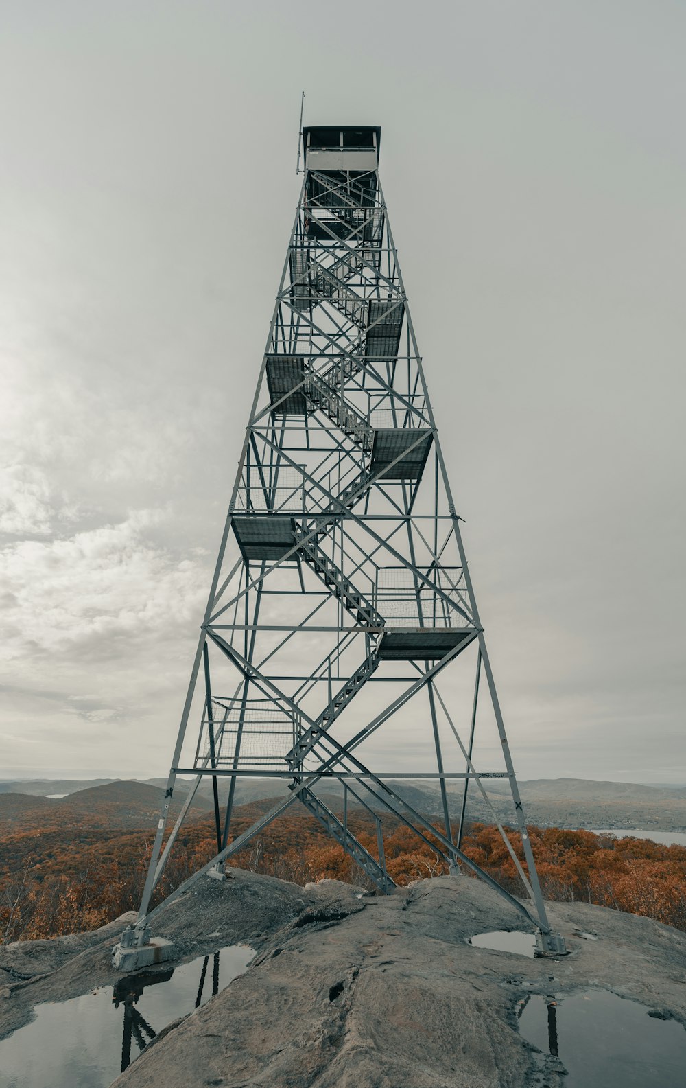 Torre de metal negro en campo marrón bajo nubes blancas