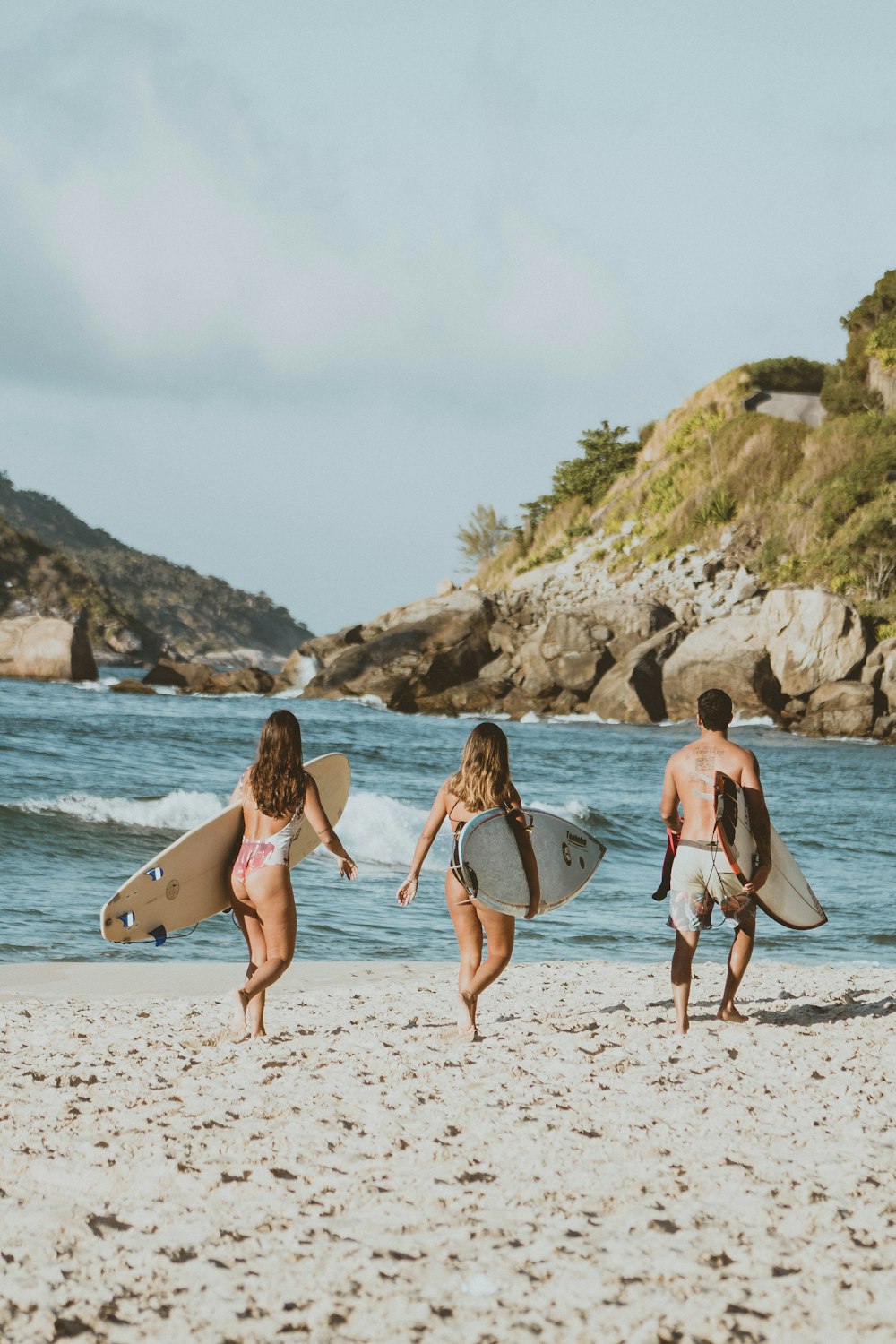 2 women in bikini walking on beach during daytime