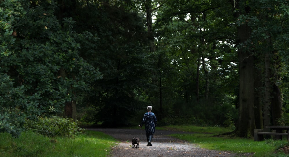 man in blue jacket walking on pathway