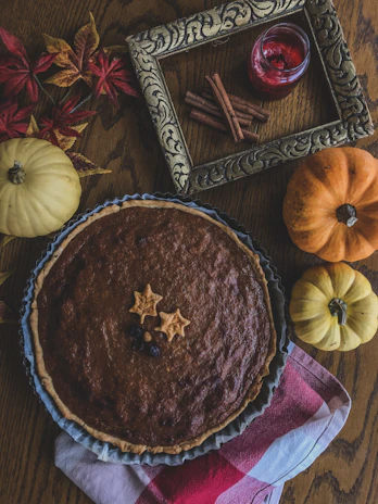 A rustic pumpkin pie with a cinnamon sprinkle, set on a cozy kitchen counter.