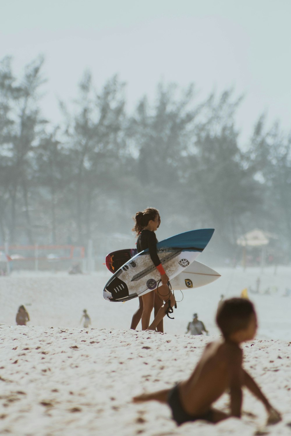 man in black wet suit carrying white surfboard on beach during daytime