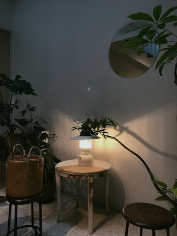 A cozy corner featuring a square end table set beside a vintage hanging light, creating a warm ambiance.