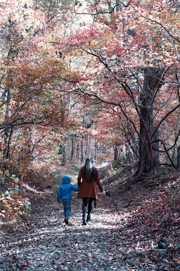 woman in red coat standing in the middle of the forest