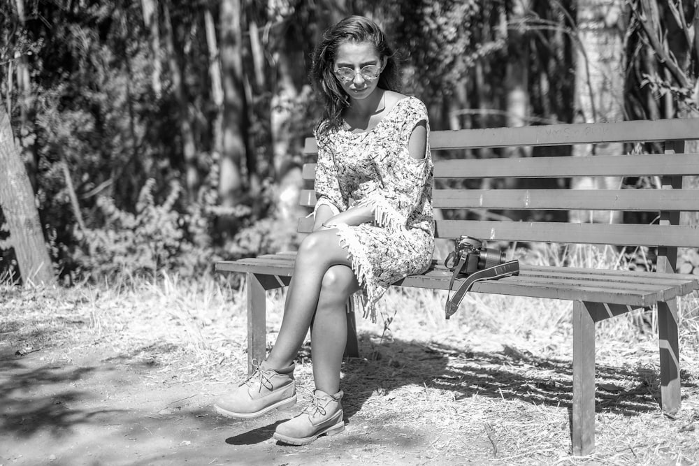 femme en robe fleurie assise sur un banc