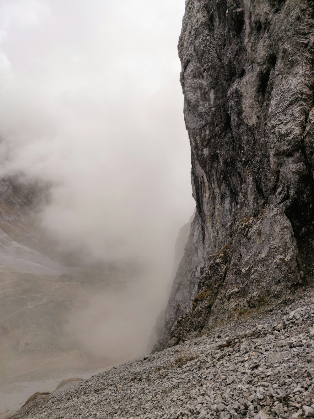 montanha rochosa cinzenta sob nuvens brancas