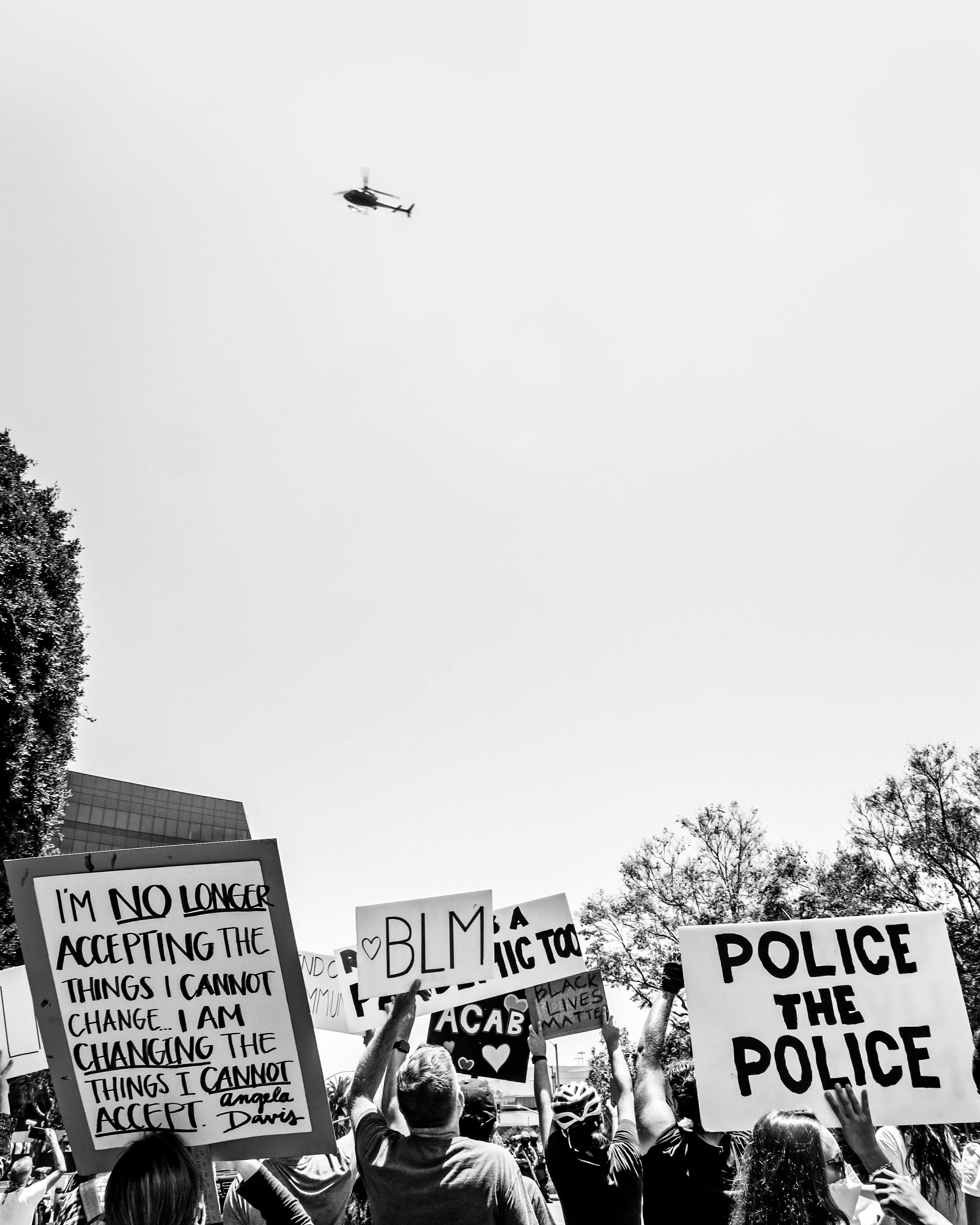grayscale photo of a plane flying over the city of the city
