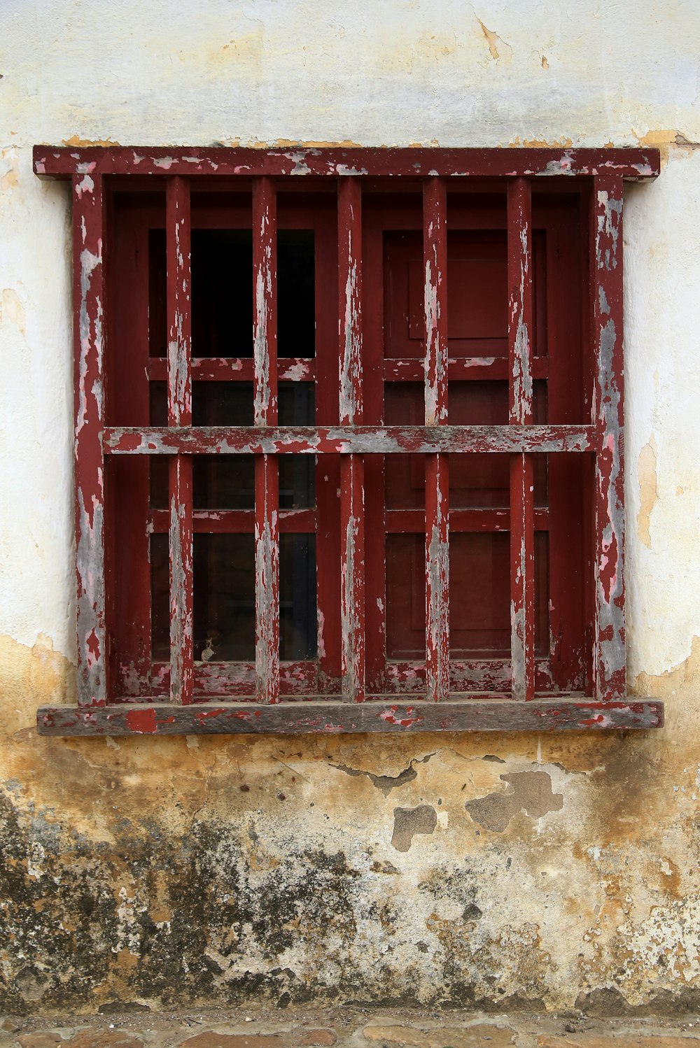 Cadre de fenêtre en bois rouge sur mur en béton brun