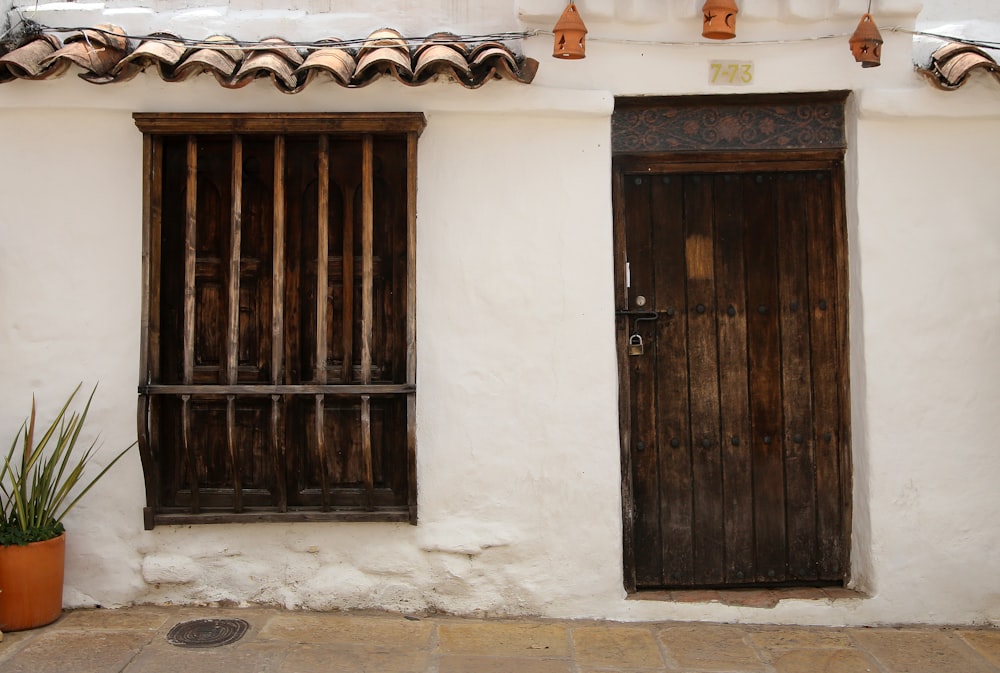 Porte en bois marron sur maison en béton blanc