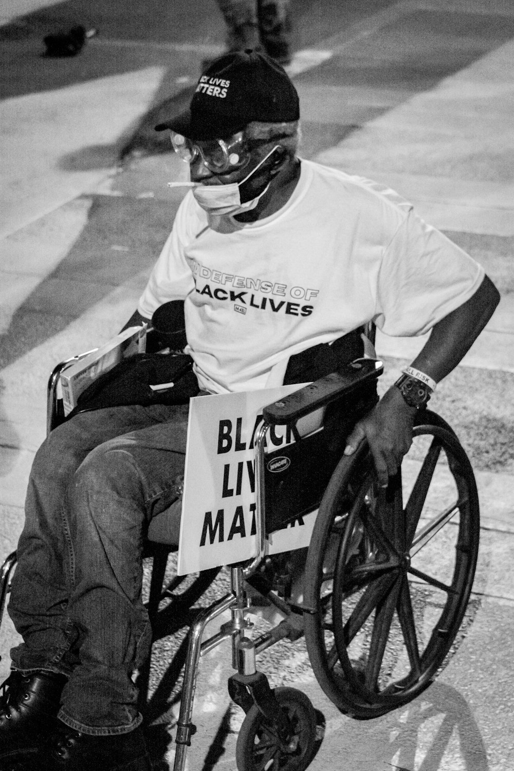 man in white t-shirt and black pants wearing black helmet riding on black bicycle