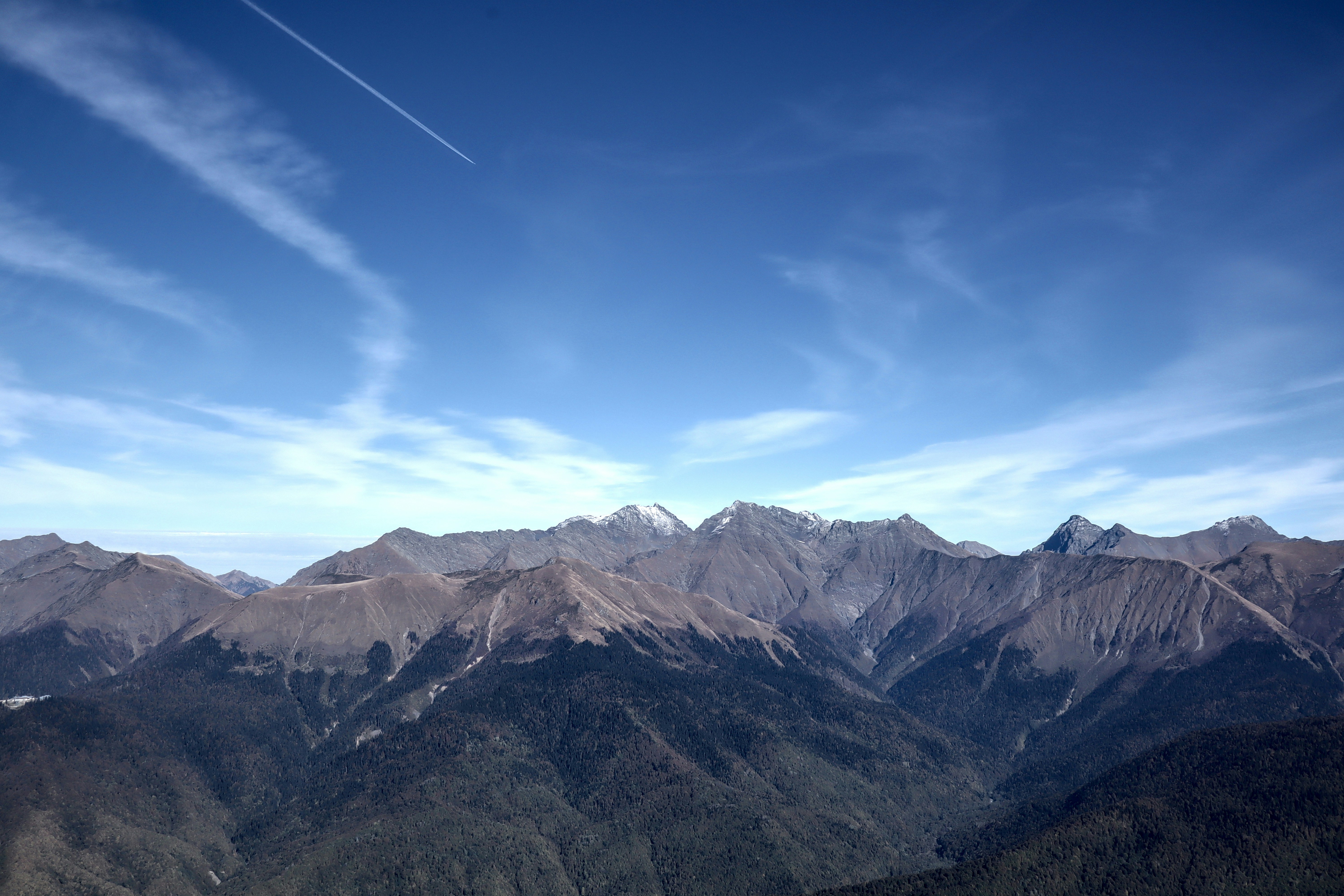 montagne marroni e verdi sotto il cielo blu durante il giorno
