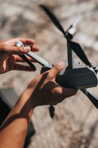 A friendly drone pilot holding a drone controller in a sunny outdoor setting.