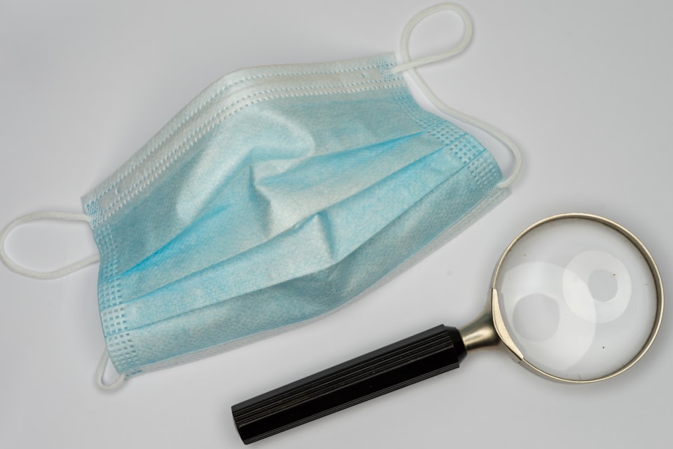 A magnifying glass and a surgical mask.