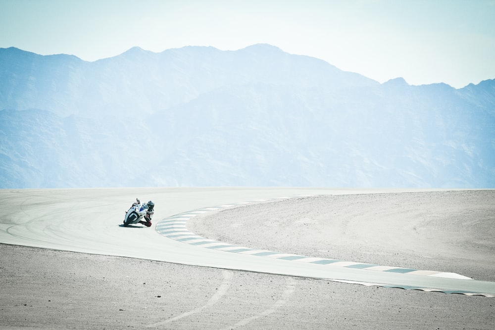 person in black jacket sitting on gray sand during daytime