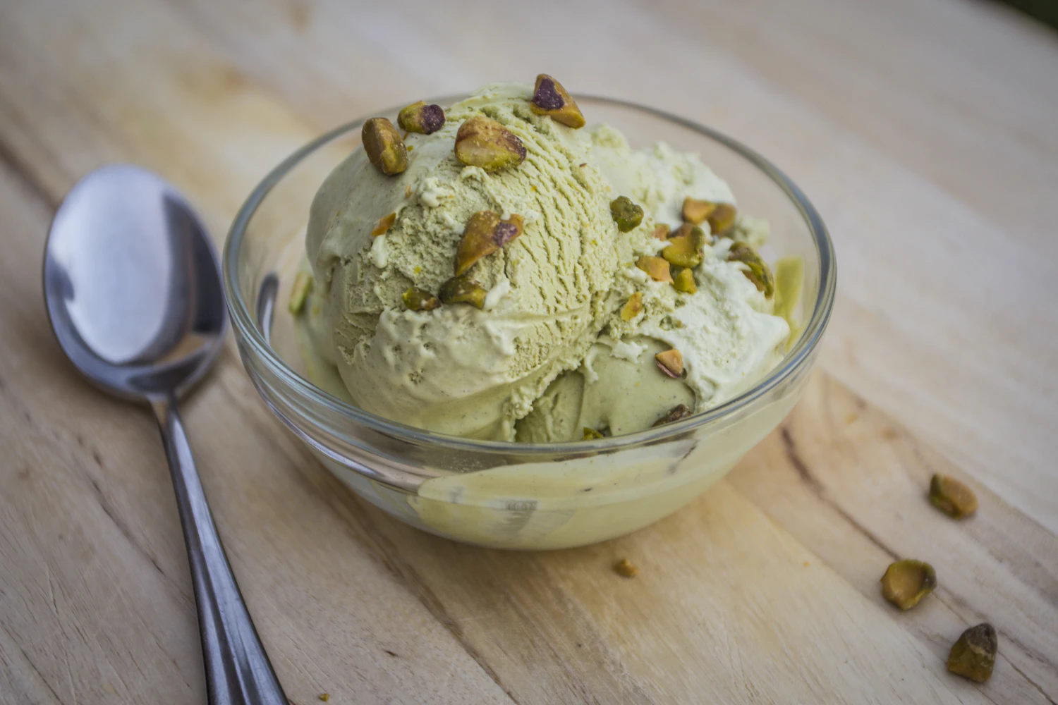 a green scoop of Pistachio Pow in a glass bowl with shelled pistachios — in the freezer today