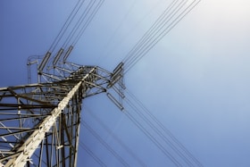 black electric post under blue sky during daytime