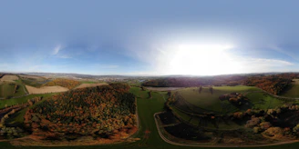 A panoramic view from the helicopter window revealing golden autumn foliage spread across rolling hills.